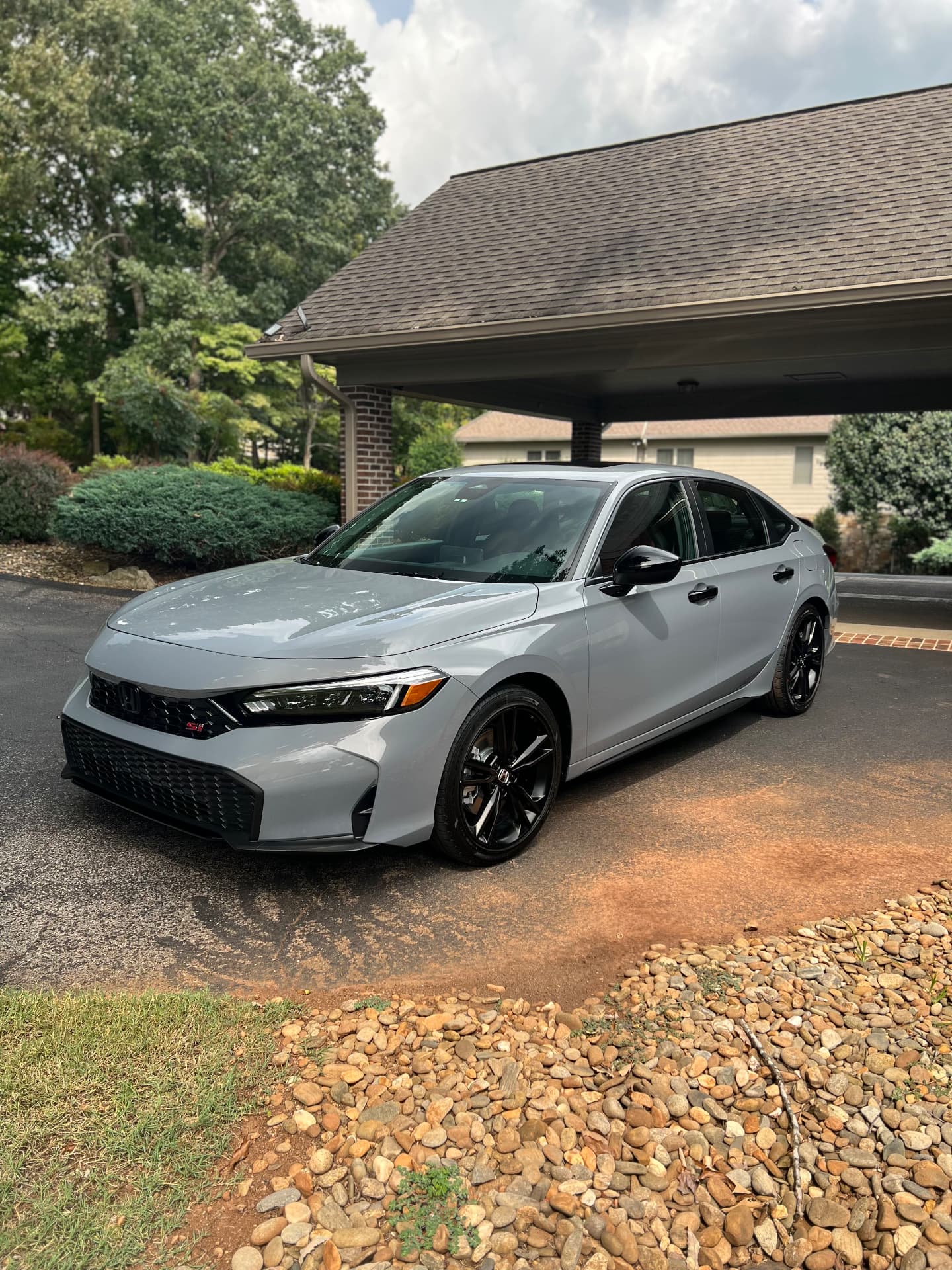 Grey Honda Civic Si with a freshly detailed, glossy finish in a driveway